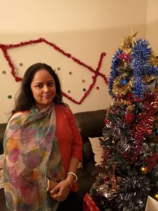 Ronita wearing her new printed scarf in front of a Christmas tree